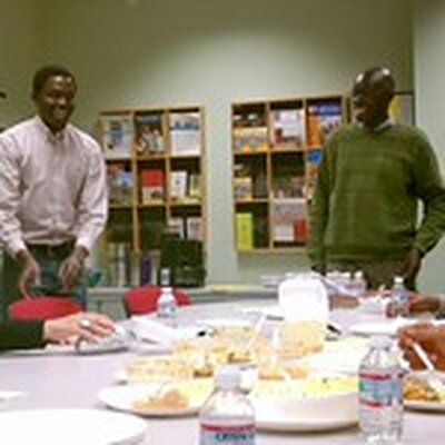 two students stand at a table of food